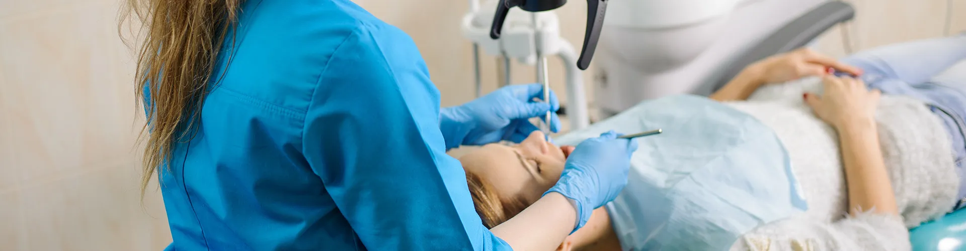 A dentist working with a female patient.