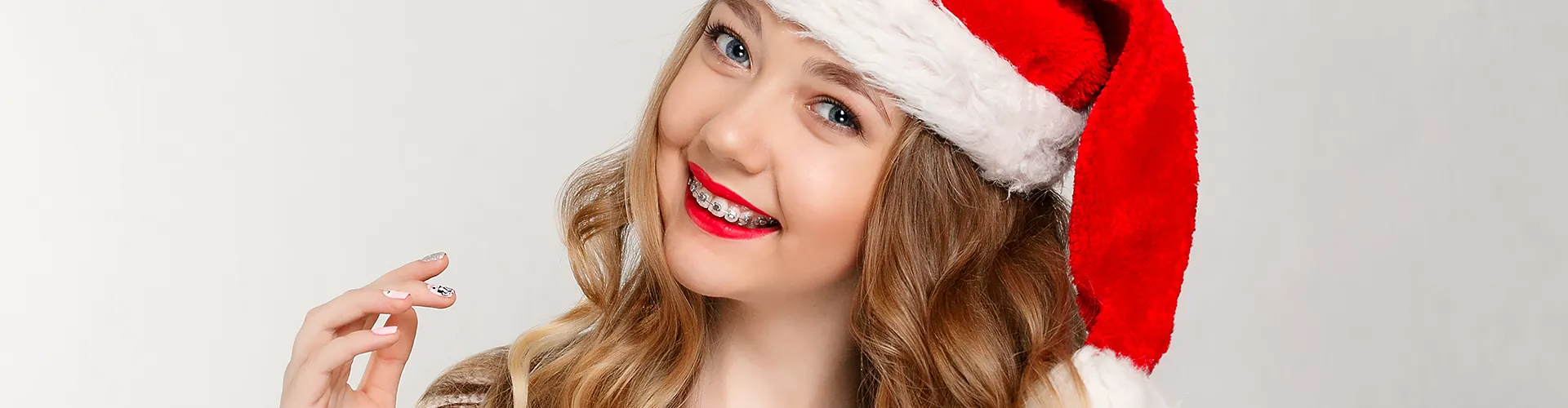 Smile girl with braces wearing santa hat.