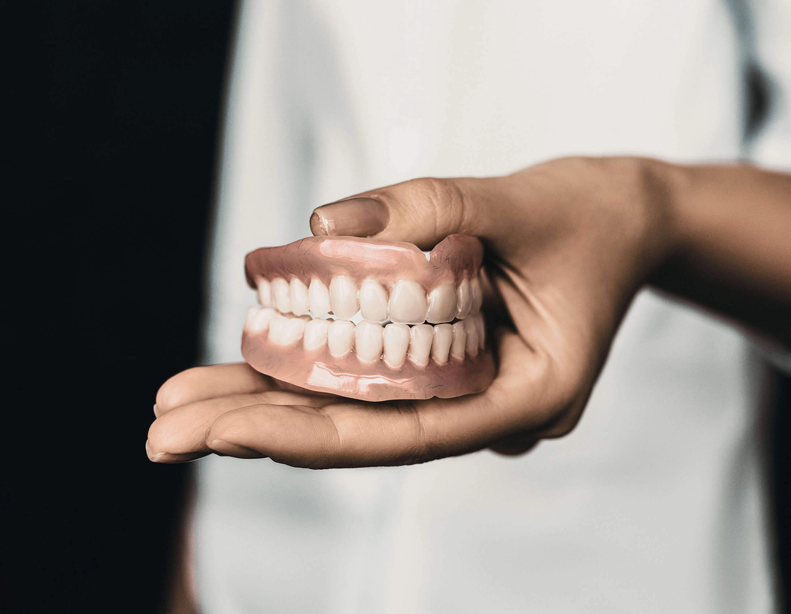 Image of dentures on a person's hand