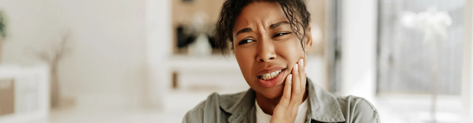 Woman holding her cheek in pain.