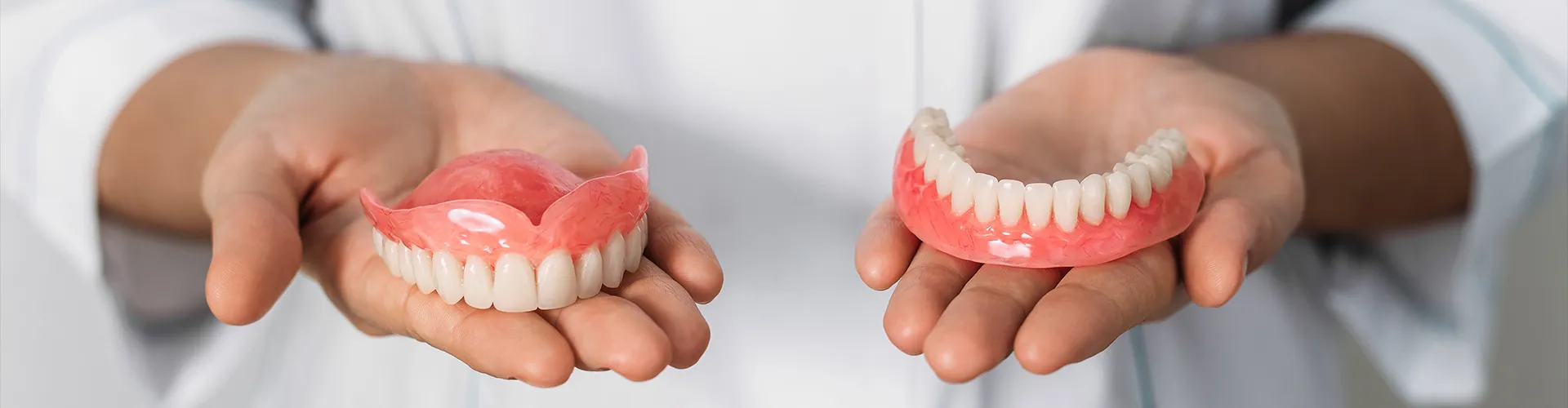 Hands holding dentures.