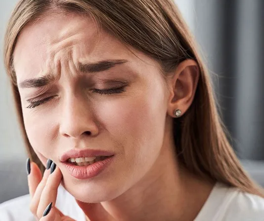 Woman in pain due to dental discomfort and potential emergency