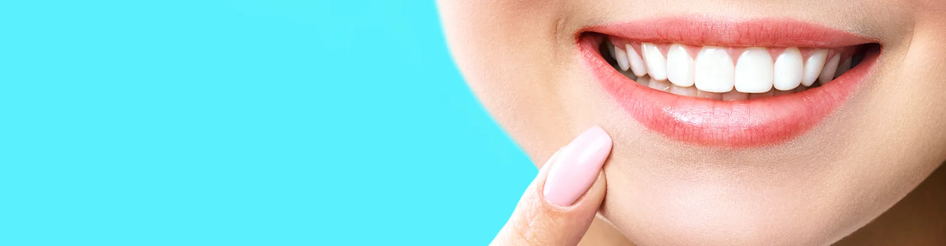 Close-up of a woman pointing to her smile.