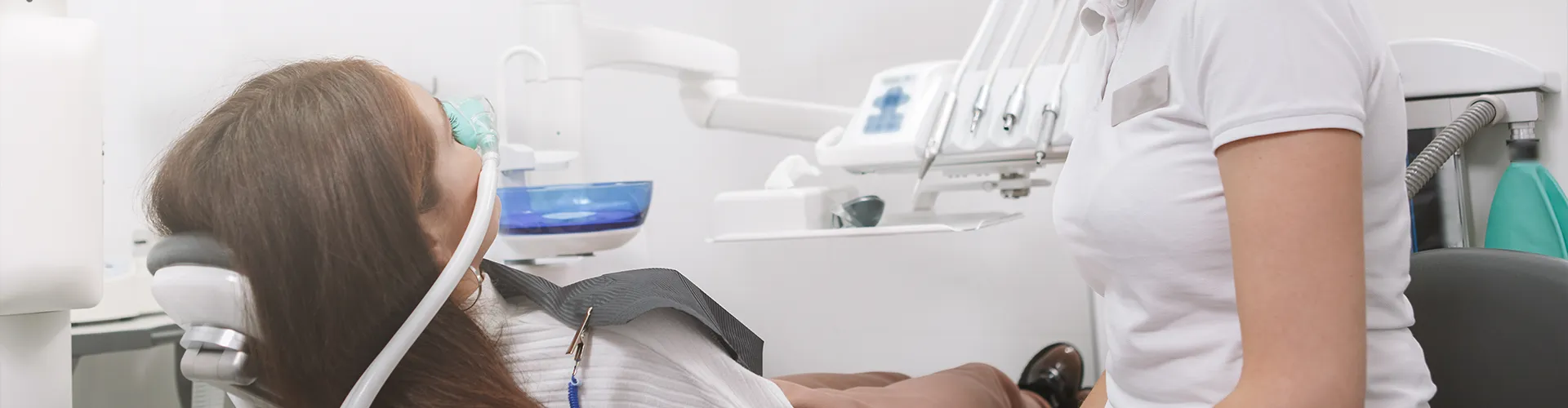 Female receiving sedation from dental professional.