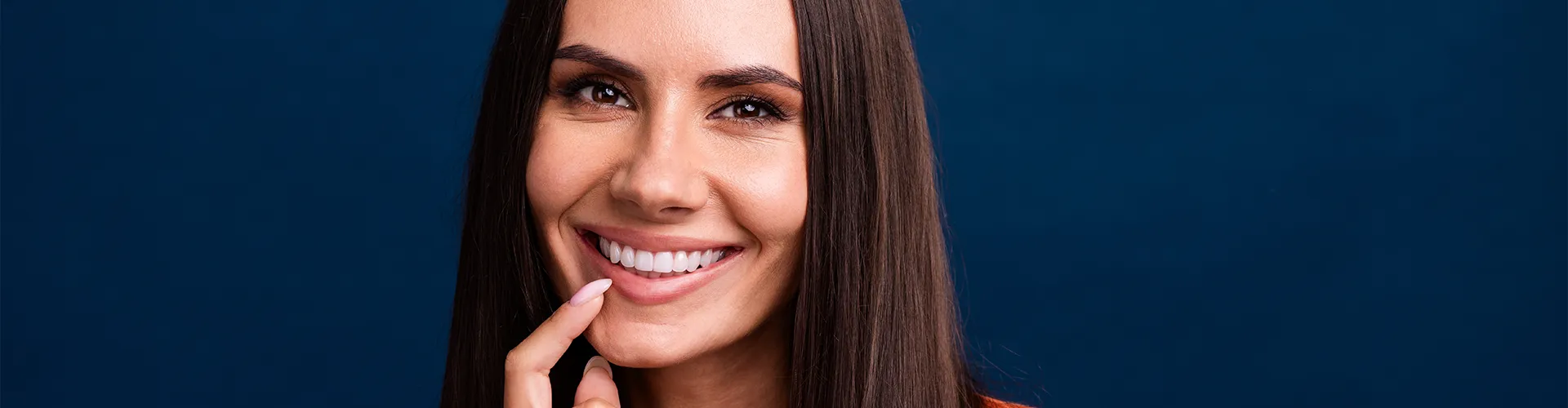 smiling woman holding her chin with her fingertips