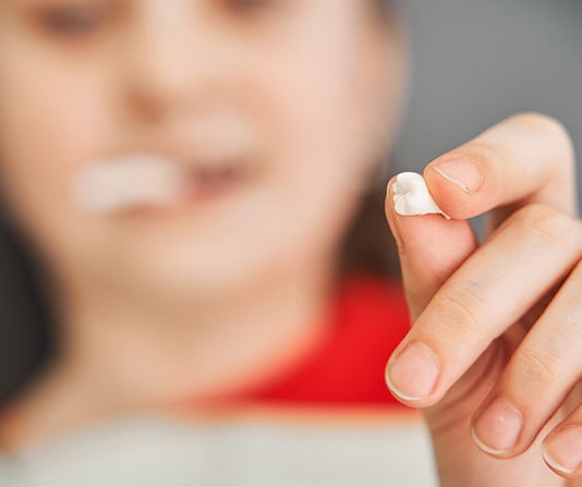 Person holding up extracted tooth
