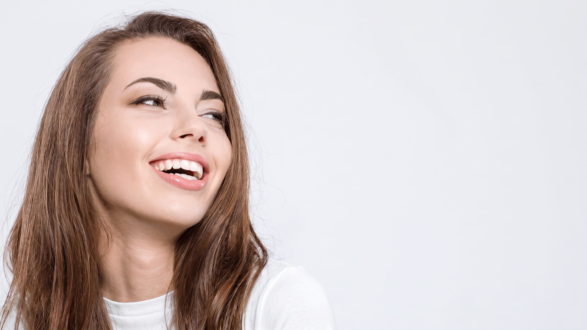 An image of a smiling lady holding a toothbrush 